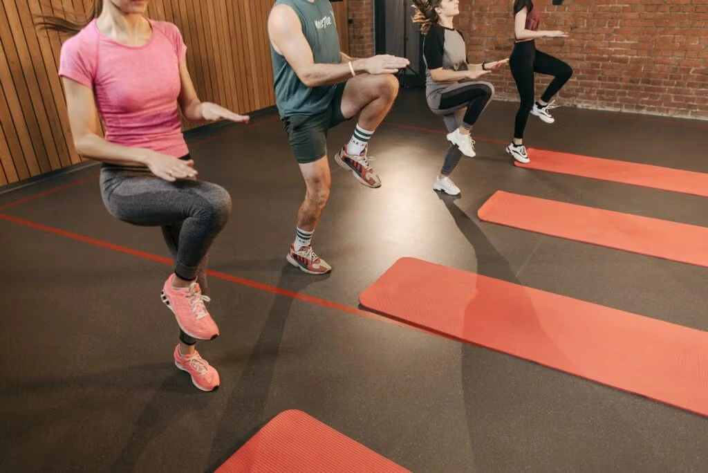 Personnes en plein entraînement HIIT en salle sur tapis de sol rouges